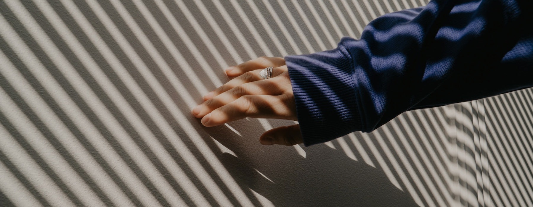 Hand against a wall of shadows